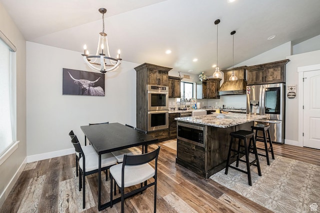 9568 N 5600 W, Elwood, UT 84337 - kitchen featuring lofted ceiling, appliances with stainless steel finishes, dark brown cabinetry, an inviting chandelier, and wood finished floors
