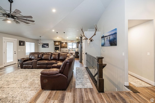9568 N 5600 W, Elwood, UT 84337 - living area with baseboards, wood finished floors, ceiling fan with notable chandelier, and lofted ceiling