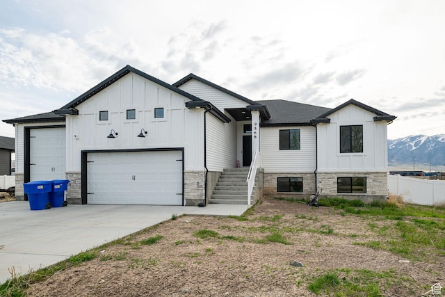9568 N 5600 W, Elwood, UT 84337 - view of front of home with board and batten siding, driveway, and stone siding