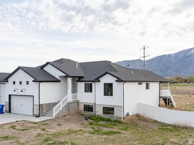 9568 N 5600 W, Elwood, UT 84337 - exterior space with driveway, stone siding, board and batten siding, roof with shingles, and fence