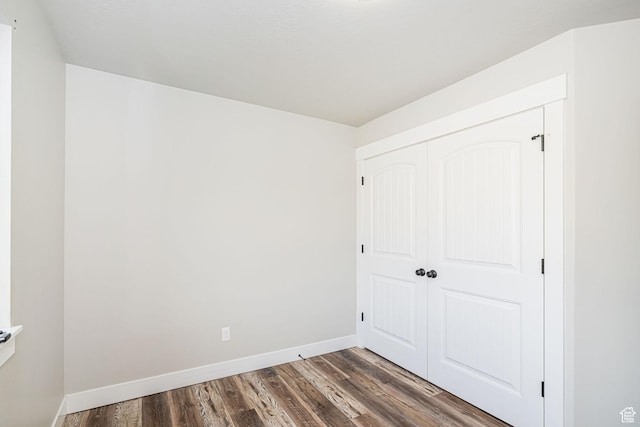 9568 N 5600 W, Elwood, UT 84337 - unfurnished bedroom featuring dark wood-style flooring, a closet, and baseboards
