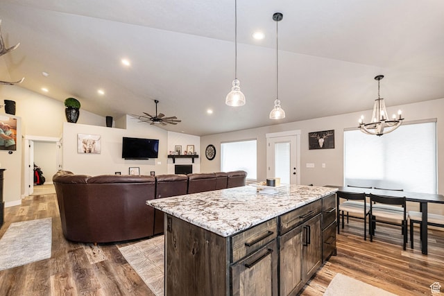 9568 N 5600 W, Elwood, UT 84337 - kitchen with wood finished floors, dark brown cabinets, ceiling fan with notable chandelier, pendant lighting, and lofted ceiling