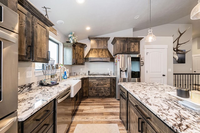 9568 N 5600 W, Elwood, UT 84337 - kitchen with a sink, appliances with stainless steel finishes, premium range hood, dark brown cabinetry, and vaulted ceiling
