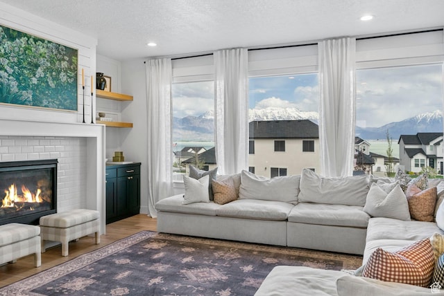 2862 S Preening Way, Saratoga Springs, UT 84045 - living room with a textured ceiling, light wood-style floors, recessed lighting, a fireplace, and a mountain view
