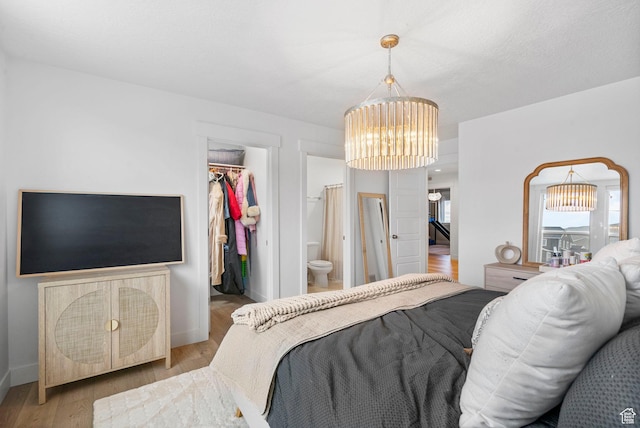 2862 S Preening Way, Saratoga Springs, UT 84045 - bedroom featuring wood finished floors, a chandelier, a closet, a walk in closet, and baseboards