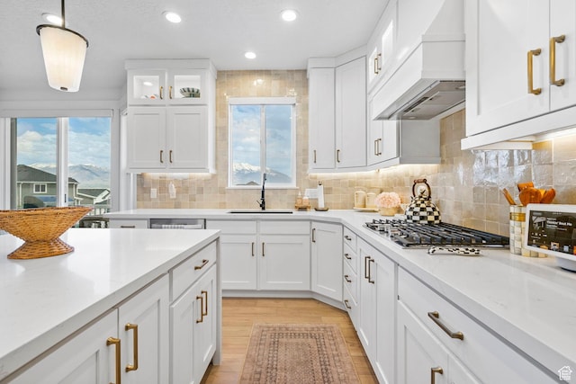 2862 S Preening Way, Saratoga Springs, UT 84045 - kitchen featuring stainless steel gas stovetop, custom range hood, white cabinets, light wood finished floors, and a sink