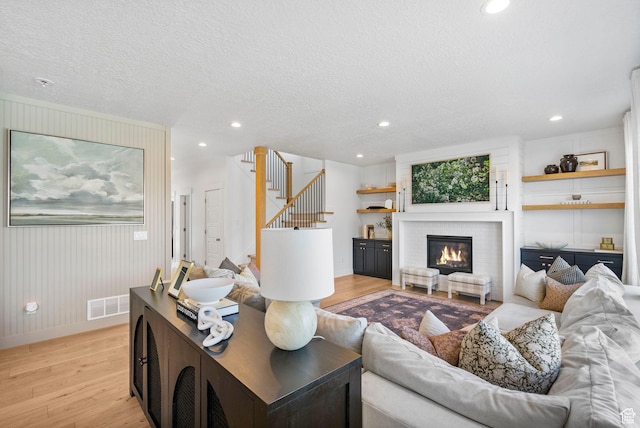 2862 S Preening Way, Saratoga Springs, UT 84045 - living room featuring visible vents, stairs, a textured ceiling, and light wood-style flooring