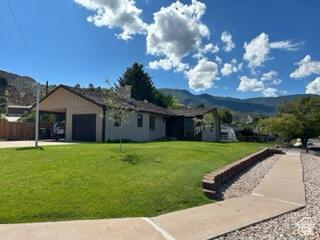 252 N Highland Dr, Cedar City, UT 84721 - exterior space with a lawn, a mountain view, and a garage