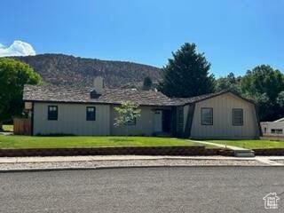 ranch-style home featuring a front yard and a mountain view
