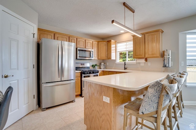 676 S 620 E, Heber City, UT 84032 - kitchen featuring appliances with stainless steel finishes, a peninsula, a breakfast bar area, light countertops, and a textured ceiling