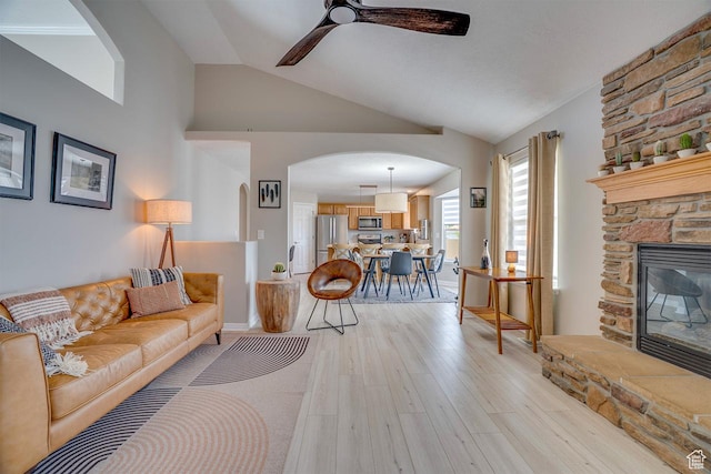 676 S 620 E, Heber City, UT 84032 - living area with arched walkways, a ceiling fan, light wood finished floors, vaulted ceiling, and a stone fireplace
