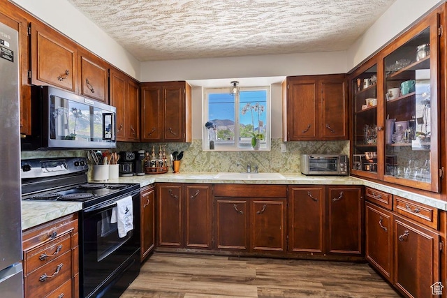 kitchen with a toaster, a sink, stainless steel appliances, and light countertops