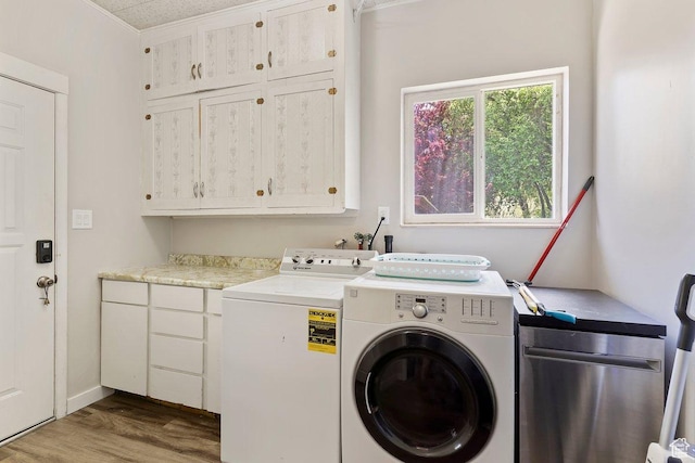 laundry area with wood finished floors, independent washer and dryer, and cabinet space