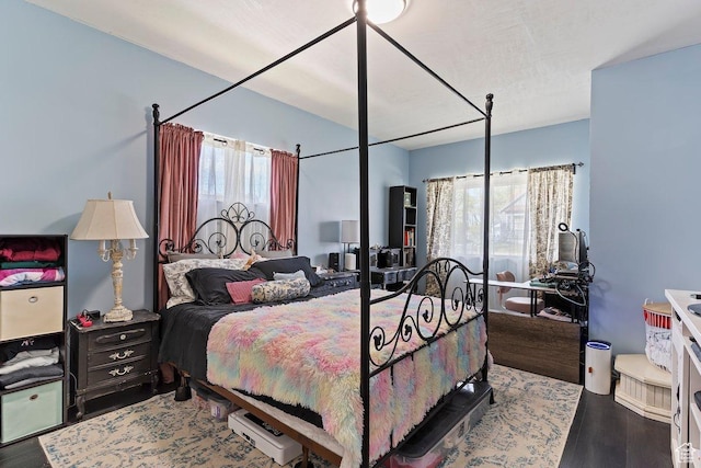bedroom with multiple windows and wood finished floors
