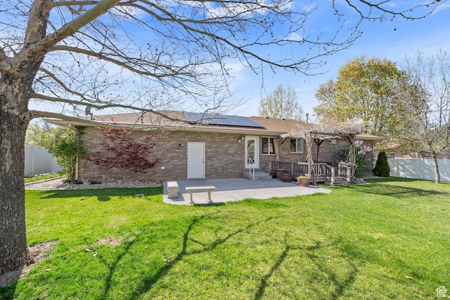 428 N 100 W, Santaquin, UT 84655 - back of house with roof mounted solar panels, a pergola, brick siding, and a fenced backyard