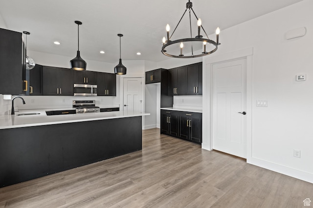 1169 N 200 E, Nephi, UT 84648 - kitchen featuring dark cabinetry, a sink, appliances with stainless steel finishes, recessed lighting, and a notable chandelier