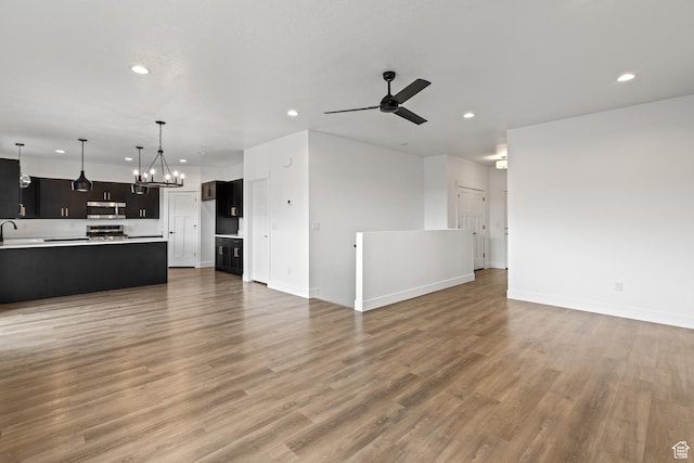 1169 N 200 E, Nephi, UT 84648 - unfurnished living room featuring light wood-type flooring, recessed lighting, ceiling fan with notable chandelier, and baseboards