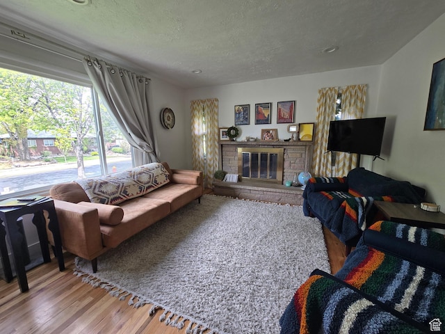 5841 S 129 W, Murray, UT 84107 - living room featuring a textured ceiling, wood finished floors, and a brick fireplace