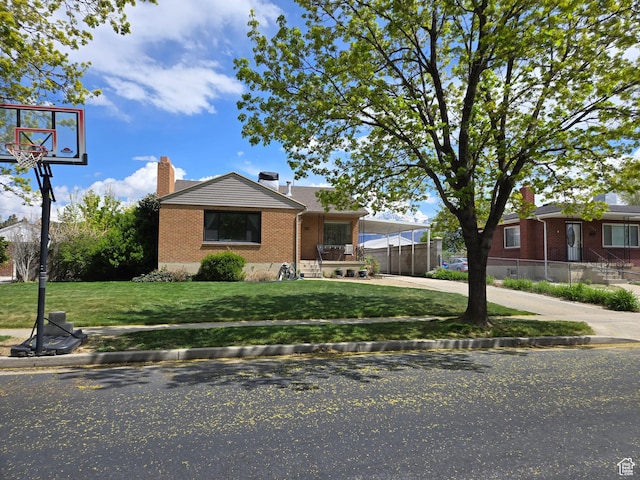 5841 S 129 W, Murray, UT 84107 - bungalow-style house featuring fence, brick siding, concrete driveway, a front lawn, and a chimney
