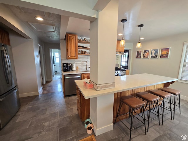 5841 S 129 W, Murray, UT 84107 - kitchen featuring a sink, stainless steel appliances, brown cabinetry, a kitchen breakfast bar, and baseboards
