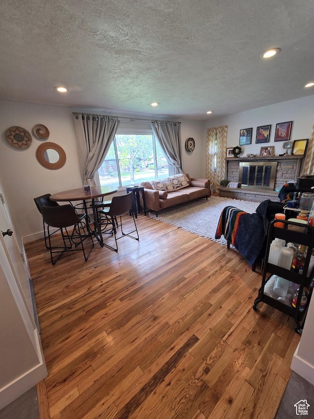 5841 S 129 W, Murray, UT 84107 - living room featuring a glass covered fireplace, recessed lighting, a textured ceiling, and hardwood / wood-style flooring