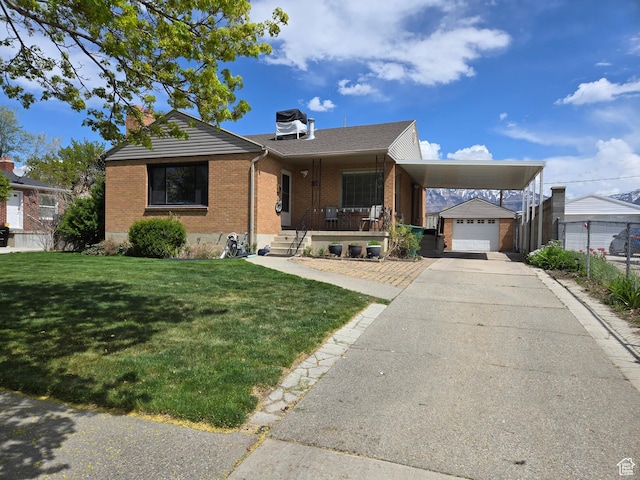 view of front of house with a front yard, driveway, a chimney, and brick siding