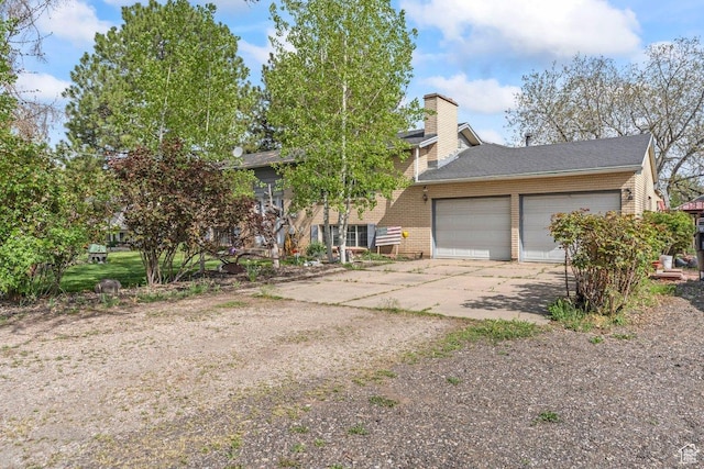 3168 W 1300 N, Clinton, UT 84015 - view of front of home featuring a chimney, brick siding, a garage, roof with shingles, and concrete driveway