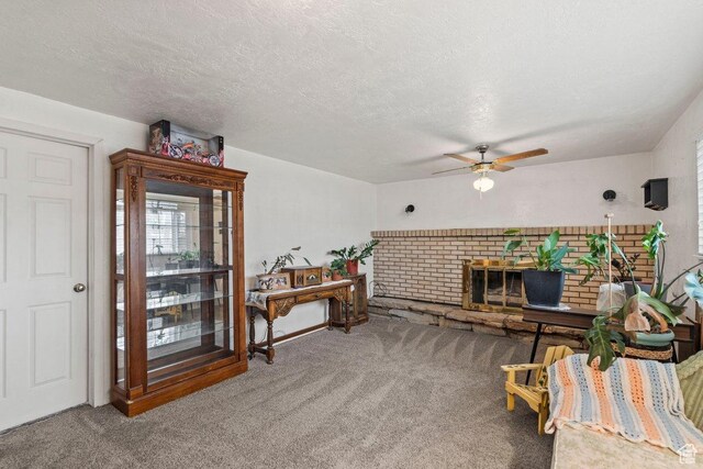 3168 W 1300 N, Clinton, UT 84015 - living area with a brick fireplace, a textured ceiling, ceiling fan, and carpet floors