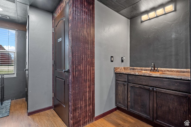 bathroom with wood finished floors, vanity, and baseboards