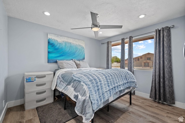 bedroom featuring recessed lighting, a ceiling fan, baseboards, a textured ceiling, and wood finished floors