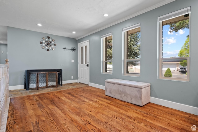 entryway featuring baseboards, recessed lighting, ornamental molding, and wood finished floors