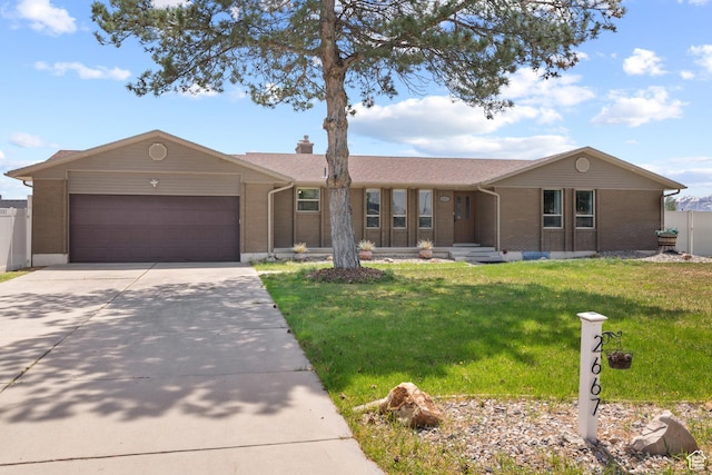 ranch-style home featuring a front yard, concrete driveway, an attached garage, and brick siding