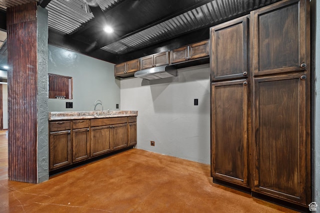 washroom featuring a textured wall and a sink