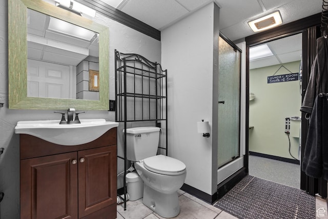 bathroom featuring toilet, a stall shower, vanity, and baseboards
