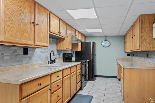 kitchen featuring electric range, under cabinet range hood, light countertops, backsplash, and a sink
