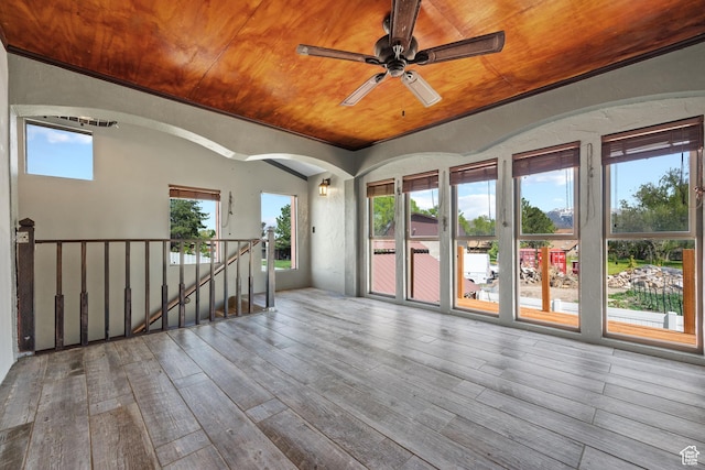 empty room featuring wood-type flooring, arched walkways, ceiling fan, and wood ceiling