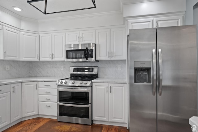 kitchen featuring ornamental molding, dark wood-style floors, white cabinets, and stainless steel appliances