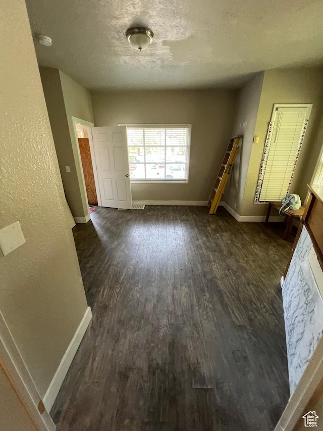 667 E 26th St S, Ogden, UT 84401 - interior space featuring dark wood-style flooring, a textured ceiling, and baseboards