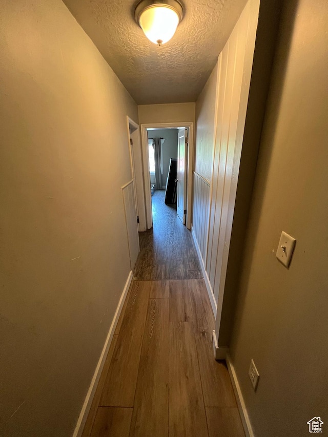667 E 26th St S, Ogden, UT 84401 - hallway featuring a textured ceiling, wood finished floors, and baseboards