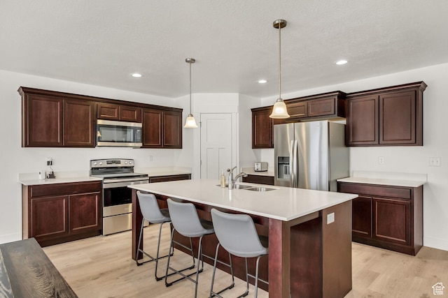 188 E Bruin Dr, Eagle Mountain, UT 84005 - kitchen featuring stainless steel appliances, light wood-type flooring, a kitchen island with sink, light countertops, and recessed lighting