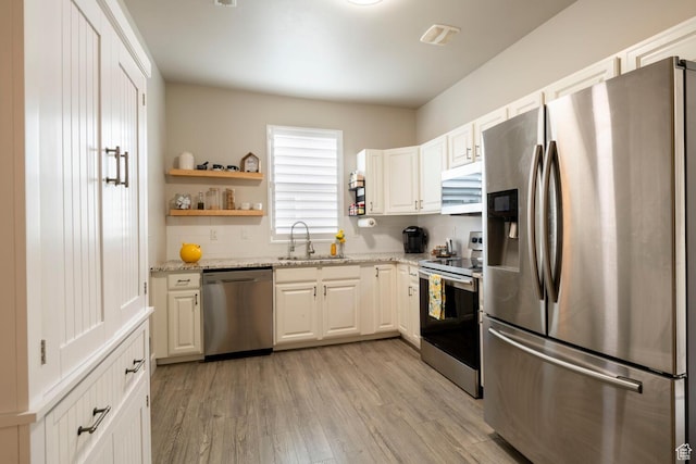 4947 W Calton Ln, South Jordan, UT 84009 - kitchen with light stone countertops, light wood-style flooring, appliances with stainless steel finishes, a sink, and white cabinetry
