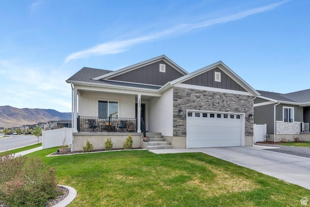 3498 N Delta St, Eagle Mountain, UT 84005 - view of front of home with a porch, concrete driveway, a garage, a mountain view, and stone siding