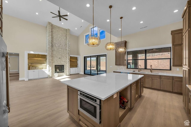 1907 S 950 W, Hurricane, UT 84737 - kitchen with stainless steel microwave, a sink, light wood-type flooring, a fireplace, and high vaulted ceiling