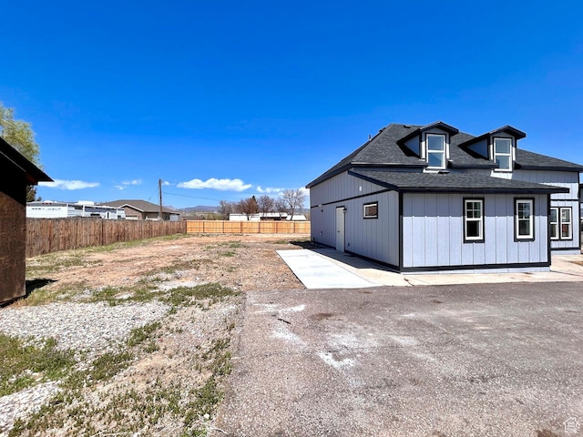 991 N 2500 W, Vernal, UT 84078 - view of home's exterior featuring a patio, fence, board and batten siding, and roof with shingles