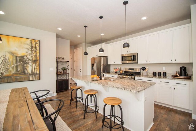 2021 W Kamari Dr, South Jordan, UT 84095 - kitchen with a kitchen breakfast bar, a sink, appliances with stainless steel finishes, dark wood-type flooring, and a kitchen island with sink