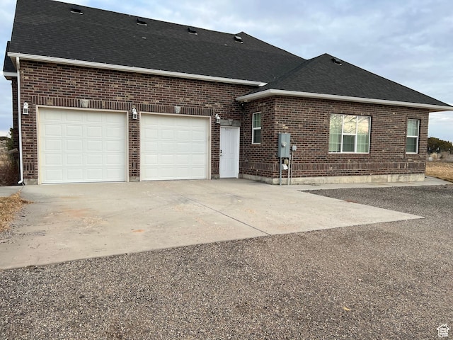 5867 W 4000 N, Roosevelt, UT 84066 - exterior space featuring a garage, brick siding, a shingled roof, and concrete driveway