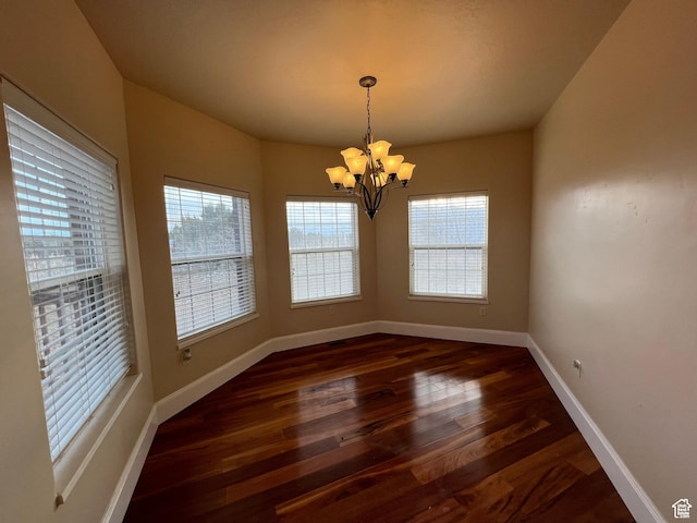 5867 W 4000 N, Roosevelt, UT 84066 - spare room featuring baseboards, a wealth of natural light, dark wood-style flooring, and an inviting chandelier