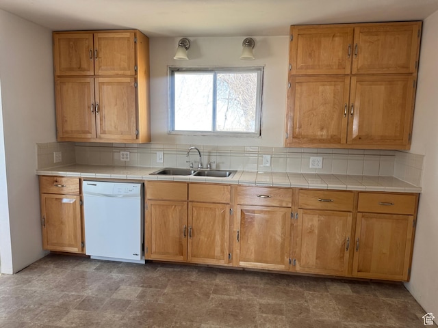 kitchen with tile counters, a sink, white dishwasher, and backsplash