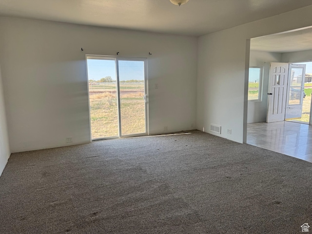 carpeted empty room featuring visible vents