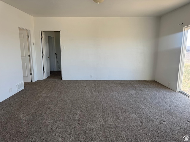 spare room with visible vents, a healthy amount of sunlight, and carpet flooring